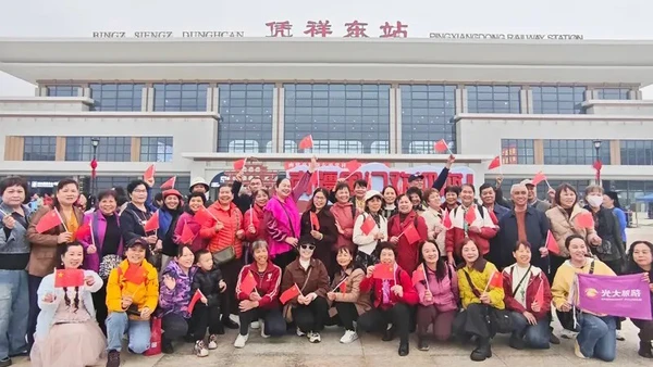 Hành khách chụp ảnh trước ga Bằng Tường Đông. (Ảnh: Nhân dân nhật báo)