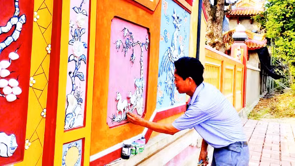 Nghệ nhân Đào Hữu Khiến thực hiện công đoạn khảm sành sứ trên bức bình phong tại Đại nội Huế.