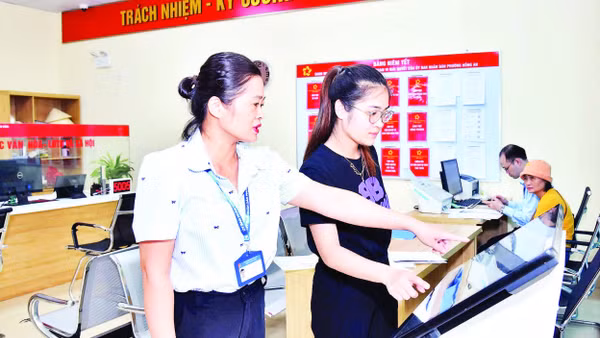 Cán bộ công chức Trung tâm Phục vụ hành chính công phường Hồng An, thành phố Hải Phòng hướng dẫn người dân thực hiện nộp hồ sơ trực tuyến. (Ảnh TRUNG KIÊN)