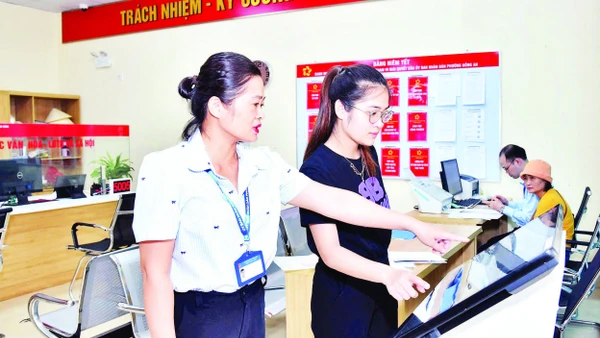 Cán bộ công chức Trung tâm Phục vụ hành chính công phường Hồng An, thành phố Hải Phòng hướng dẫn người dân thực hiện nộp hồ sơ trực tuyến. (Ảnh TRUNG KIÊN)