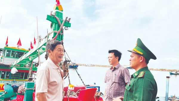 Chiến sĩ Đồn Biên phòng Thanh Hải (Lâm Đồng) cùng với cán bộ Ủy ban nhân dân phường Phú Thủy tuyên truyền ngư dân về trước ngày bỏ phiếu bầu cử. (Ảnh: THANH HẢI)