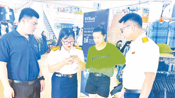 Công chức Thuế tỉnh Quảng Ninh trực tiếp hỗ trợ các hộ kinh doanh, nhất là các hộ vừa chuyển thành doanh nghiệp, cài đặt và sử dụng ứng dụng eTax Mobile.