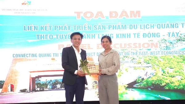 Đại diện lãnh đạo Sở Văn hóa, Thể thao và Du lịch Quảng Trị (bên trái) tặng quà cho đại biểu dự Tọa đàm.