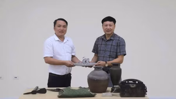 Phó Giám đốc Bảo tàng tỉnh Quảng Trị Mai Thế Trung (áo trắng) trao hiện vật, tư liệu phục vụ xây dựng Bảo tàng Đảng Cộng sản Việt Nam 