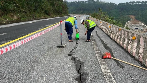 Công nhân giao thông tiến hành nhồi dây đay, tưới nhựa để bịt vết nứt nhằm ngăn nước thấm xuống phía dưới đường.