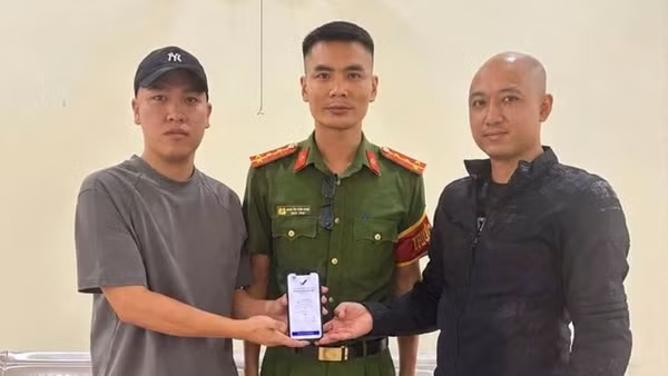 Anh Hoàng Quốc Cường (bên trái) trả lại 5 tỷ đồng chuyển khoản nhầm cho anh Quân trước sự chứng kiến của đại diện Công an xã Hoàn Lão. (Ảnh: Công an xã Hoàn Lão)