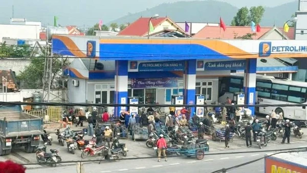 Cảnh người dân kéo xe ba gác với nhiều can nhựa đến mua xăng dầu tại cửa hàng ở khu vực Roòn, xã Phú Trạch sáng nay.