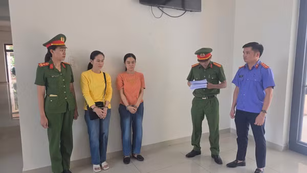 Cơ quan điều tra tống đạt quyết định khởi tố bị can, lệnh bắt tạm giam hai đối tượng Phùng Thị Minh Sen và Ngô Thùy Linh. (Ảnh: Công an Đà Nẵng cung cấp)