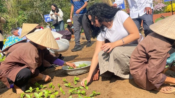 Du khách quốc tế tham gia trồng rau tại Lễ hội cầu bông Trà Quế, thành phố Đà Nẵng.