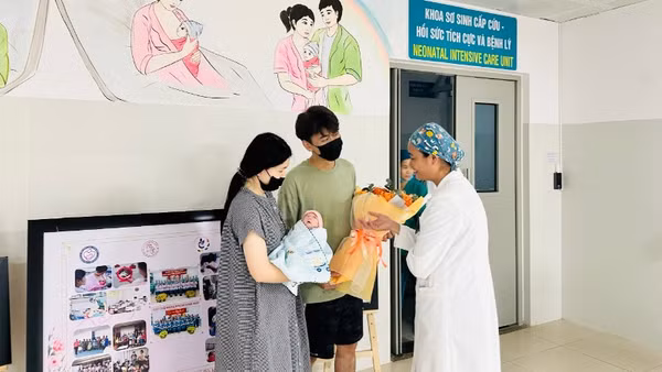 Gia đình nhỏ hạnh phúc đón nhận tình cảm từ các y bác sĩ Bệnh viện Phụ sản-Nhi Đà Nẵng trong ngày xuất viện. (Ảnh: Bệnh viện cung cấp)