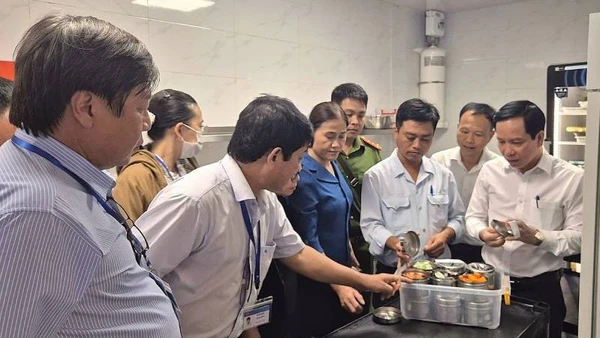 Phó Giám đốc Sở Y tế Tây Ninh Mai Văn Dũng (bìa phải), Trưởng đoàn số 1 của tỉnh kiểm tra, hậu kiểm việc lưu giữ mẫu thực phẩm tại Nhà hàng Buffet Vân Sơn.
