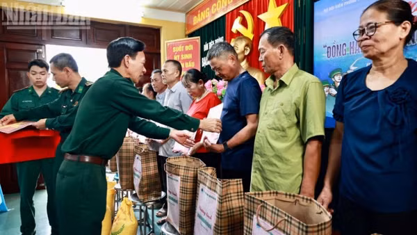 Thượng tá Nguyễn Văn Lập, Chủ nhiệm chính trị Bộ đội Biên phòng thành phố Hải Phòng trao quà và tặng cờ Tổ quốc cho các hộ dân trên đảo.