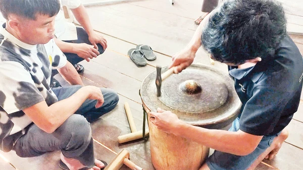 Các học viên thực hành chỉnh âm cồng chiêng tại lớp tập huấn do nhà nghiên cứu Bùi Trọng Hiền hướng dẫn. 