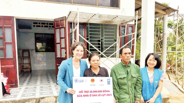 Gia đình nhận hỗ trợ sửa nhà ở sau lũ lụt. Ảnh UNDP