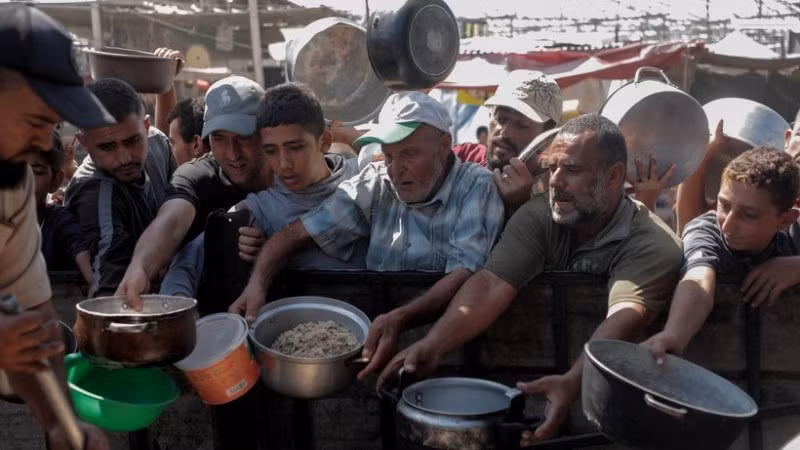 Người dân nhận thức ăn cứu trợ tại thành phố Khan Younis, Dải Gaza. (Ảnh: THX/TTXVN)