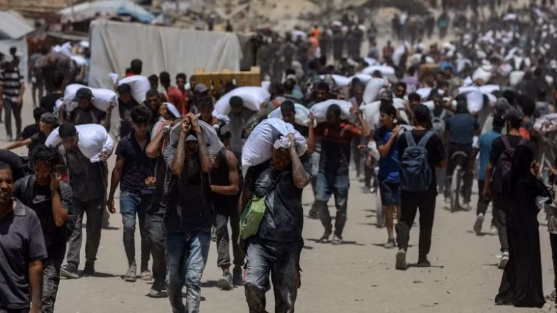 Người dân Palestine nhận hàng viện trợ nhân đạo tại Beit Lahia, phía Bắc Dải Gaza, ngày 1/8/2025. (Ảnh: THX/TTXVN)