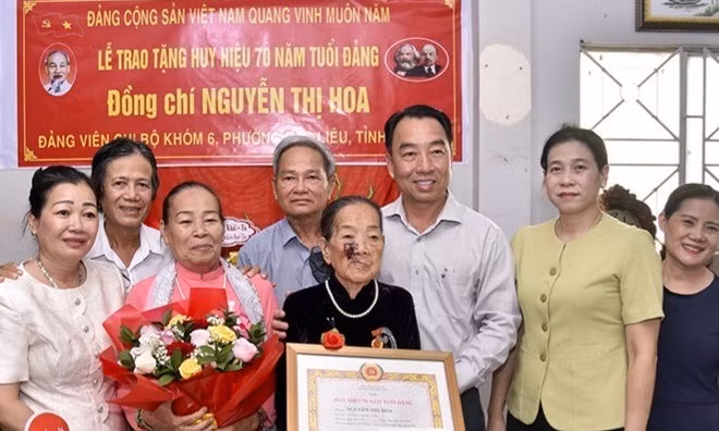 Đồng chí Lữ Quang Ngời (thứ ba, từ phải sang), Phó Bí thư Tỉnh uỷ, Chủ tịch Ủy ban nhân dân tỉnh Cà Mau và đồng chí Tô Việt Thu, Ủy viên Ban Thường vụ Tỉnh uỷ, Bí thư Đảng ủy phường Bạc Liêu (thứ hai từ phải sang) chụp ảnh lưu niệm cùng đảng viên lão thành Nguyễn Thị Hoa và gia đình.