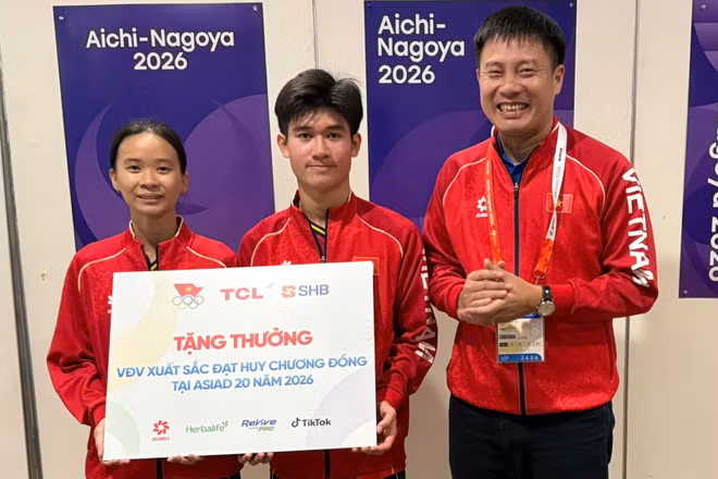 Bộ đôi Nguyễn Hoàng Minh Tân-Trịnh Gia Nghi nhận thưởng sau khi đạt Huy chương Đồng Asian Games. (Ảnh: Bùi Lượng)
