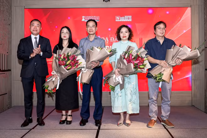 Ông Phạm Quốc Huy - Tổng Biên tập Tạp chí Đời sống và Pháp luật tặng hoa cho các diễn giả tại tọa đàm. (Ảnh: TRỌNG TÙNG)