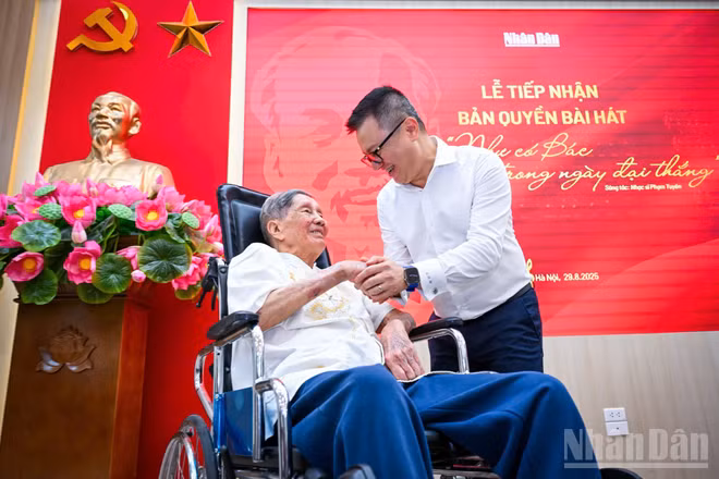 Nhạc sĩ Phạm Tuyên và Tổng Biên tập Báo Nhân Dân Lê Quốc Minh tại buổi lễ tiếp nhận. (Ảnh: THÀNH ĐẠT)
