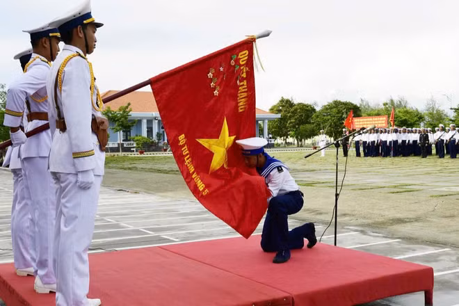 Chiến sĩ mới hôn Quân kỳ Quyết thắng. (Ảnh: Văn Định)