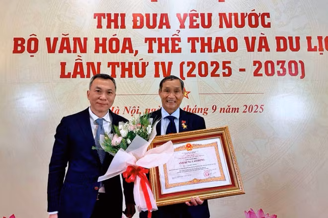 Chủ tịch Liên đoàn Bóng đá Việt Nam Trần Quốc Tuấn chúc mừng huấn luyện viên Mai Đức Chung được trao danh hiệu Anh hùng Lao động. 
