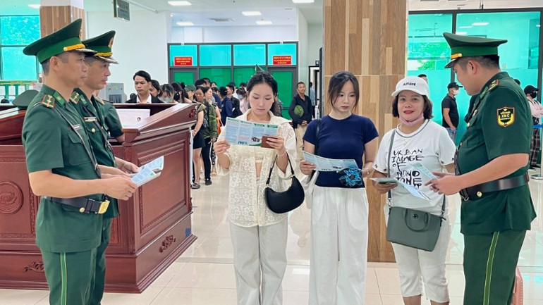 Trạm kiểm soát biên phòng cửa khẩu Quốc tế Lào Cai phát tờ rơi tuyên truyền pháp luật cho hành khách qua cửa khẩu. bplc2-5953.jpg