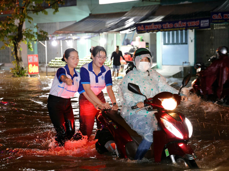 Sinh viên Đại học Cần Thơ hỗ trợ người dân di chuyển qua vùng ngập sâu. nuoc.jpg