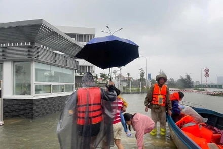 Lực lượng chức năng đưa bà con trong vùng ngập nặng đến tránh trú tại FPT School Huế.