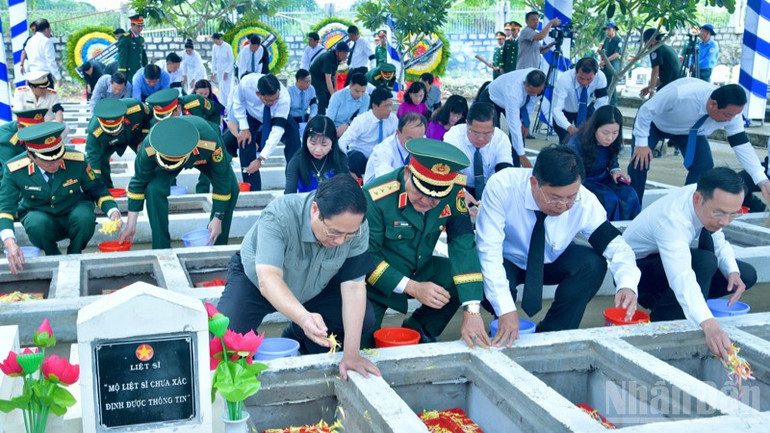 Thủ tướng Phạm Minh Chính và các đồng chí lãnh đạo rắc hoa và đất xuống các phần mộ liệt sĩ mới được an táng. (Ảnh: THANH GIANG) ndo_br_a6-7168.jpg