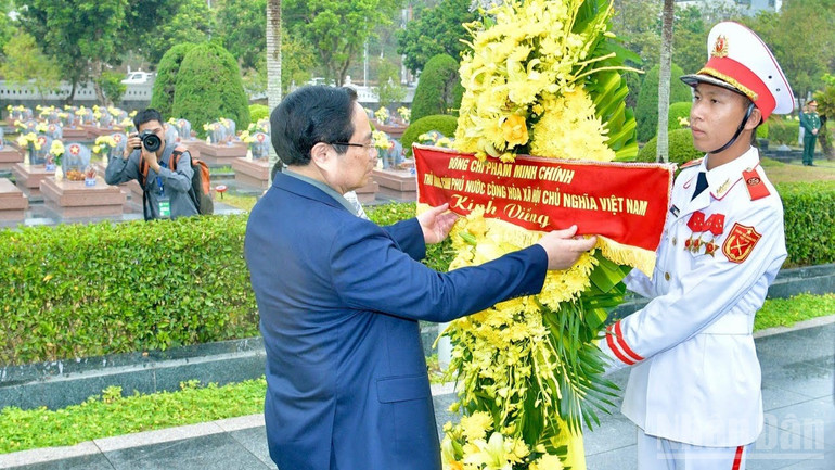 Thủ tướng Phạm Minh Ch&iacute;nh chỉnh hoa trước khi thực hiện nghi lễ d&acirc;ng hương, d&acirc;ng hoa tưởng nhớ c&aacute;c Anh h&ugrave;ng liệt sĩ tại Nghĩa trang liệt sĩ quốc gia A1. (Ảnh: THANH GIANG)