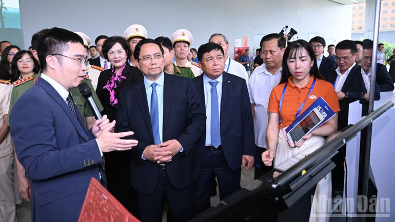 Thủ tướng Phạm Minh Chính tham quan gian trưng bày của Tập đoàn FPT trong khuôn khổ Lễ khai trương. (Ảnh: TRẦN HẢI) ndo_br_d3-3366.jpg