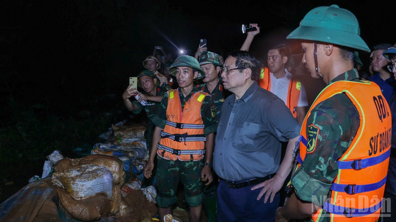 Thủ tướng Phạm Minh Chính thị sát tình nước lũ dâng cao ở bờ sông, nguy cơ tràn qua đê. (Ảnh: Trần Hải) ndo_br_a2-8804.jpg