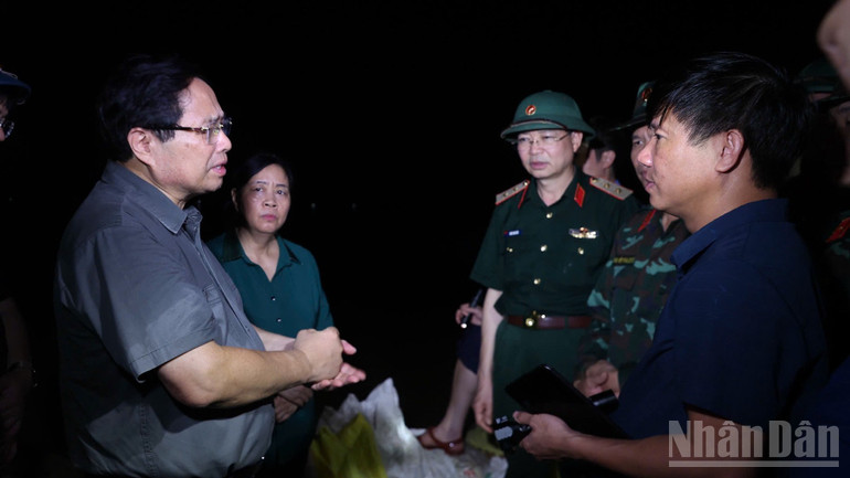 Thủ tướng Phạm Minh Chính trao đổi các phương án ứng phó với lãnh đạo thành phố Hà Nội, các cơ quan, lực lượng chức năng tại hiện trường. (Ảnh: Trần Hải) ndo_br_a4-7621.jpg