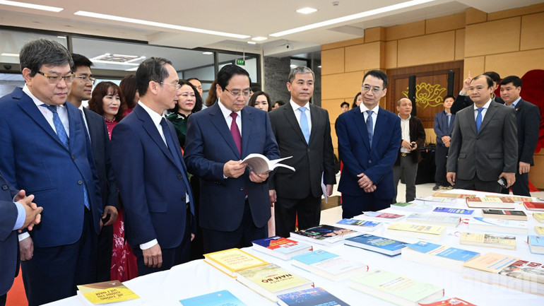 Thủ tướng Phạm Minh Chính tham quan khu trưng bày sách và giới thiệu về các hoạt động của Học viện Hành chính và Quản trị công. (Ảnh: Trần Hải)