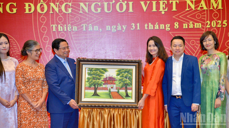 Thủ tướng Phạm Minh Chính tặng quà lưu niệm cho bà con cộng đồng người Việt Nam tại Trung Quốc. (Ảnh: THANH GIANG) ndo_br_a5-4538.jpg