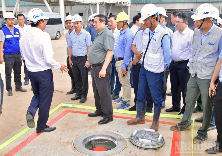 Premiärminister Pham Minh Chinh inspekterar en tankstation för flygplan på asfalten. (Foto: Thanh Giang) ndo_br_a2-8849.jpg