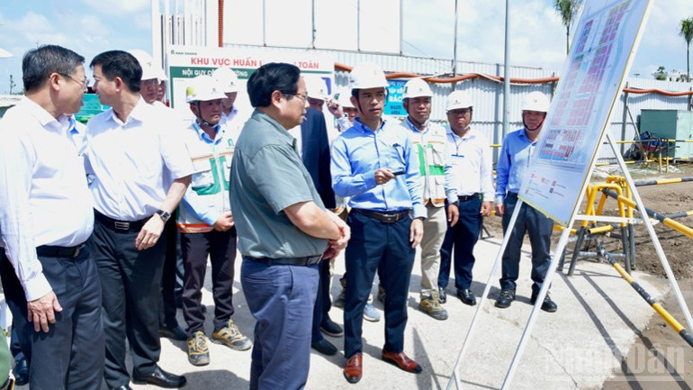 Prime Minister Pham Minh Chinh listened to the investor report on the progress of the social housing and commercial housing development project. (Photo: Thanh Giang) ndo_br_a1-3679-1973.jpg