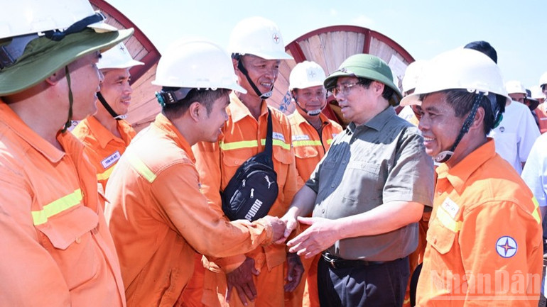 Thủ tướng Phạm Minh Chính hỏi thăm, động viên các kỹ sư, công nhân Tập đoàn Điện lực Việt Nam (EVN) trên công trường. (Ảnh: TRẦN HẢI) ndo_br_a11-3942.jpg