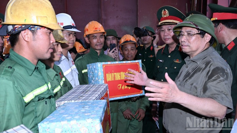 Thủ tướng Phạm Minh Chính tặng quà đội thi công của Tổng công ty Xây dựng Trường Sơn đang khẩn trương thi công hạng mục chuẩn bị cho hợp long cầu Phong Châu những ngày tới. ndo_br_b7-9028.jpg