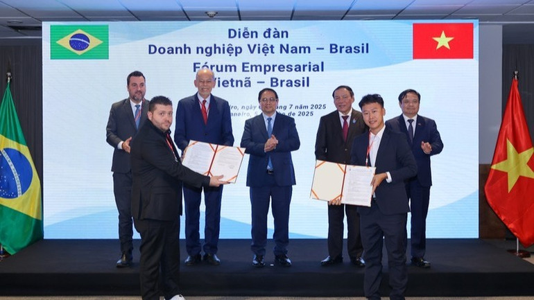 Thủ tướng Phạm Minh Chính và các đại biểu chứng kiến lễ trao thỏa thuận hợp tác giữa Công ty Cổ phần Nam Việt (NAVICO) và AV09 Comercio Exporter Ltda trong lĩnh vực thủy sản. (Ảnh: VGP/Nhật Bắc) ab5-108.jpg