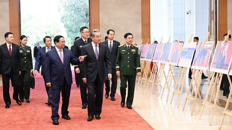 Thủ tướng Chính phủ Phạm Minh Chính giới thiệu với 3 Bộ trưởng của Trung Quốc không gian triển lãm ảnh về quan hệ hai nước. (Ảnh: TRẦN HẢI)