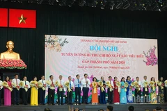 Lãnh đạo Thành phố Hồ Chí Minh trao tặng biểu trưng và hoa chúc mừng các đồng chí Bí thư chi bộ được tuyên dương. (Ảnh Linh Bảo)
