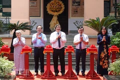 Các đại biểu thực hiện nghi thức cắt băng khai mạc trưng bày. (Ảnh: MẠNH HẢO)