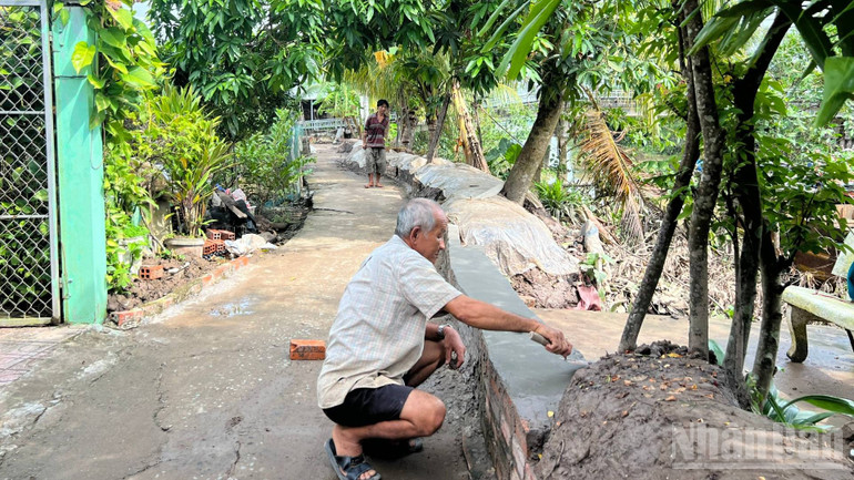 Gia đình ông Nguyễn Văn Ảnh dùng xi măng, gạch xây tường ngăn không cho nước vào bên trong. ndo_br_5-24.jpg