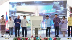 Phó Thủ tướng hai nước Lào-Thái Lan và đại diện các bộ, ngành hai nước thực hiện nghi thức đổ bê tông hợp long cầu. (Ảnh: XUÂN TÚ/TTXVN)