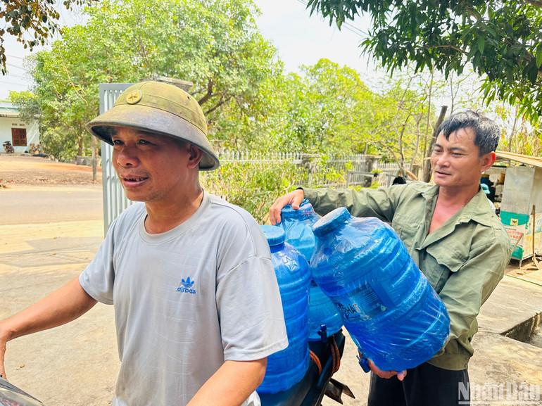 Anh Phạm Văn Mừng cùng anh em trong thôn chuyển bình đến cửa hàng chờ đổi bình nước mới. Anh Phạm Văn Mừng cùng anh em trong thôn chuyển bình đến cửa hàng chờ đổi bình nước mới.