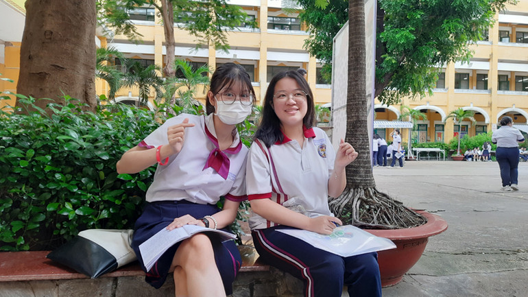 Hai thí sinh tươi vui, thoải mái tạo dáng chụp ảnh trước khi bước vào Kỳ thi trung học phổ thông năm 2024.