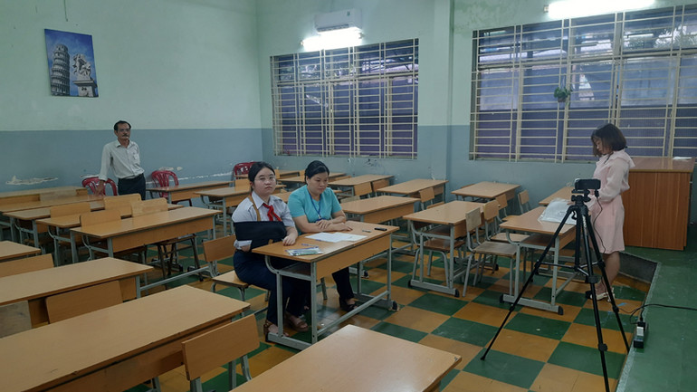 Đồng thời, có 2 cán bộ coi thi như các phòng thi khác và có thêm một cán bộ hỗ trợ thí sinh viết bài (ngồi cạnh thí sinh, áo màu xanh).