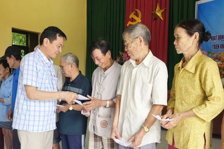 Đại diện Báo Nhân Dân tại Quảng Trị trao tiền cho người dân thôn Hội Kỳ, xã Nam Hải Lăng.